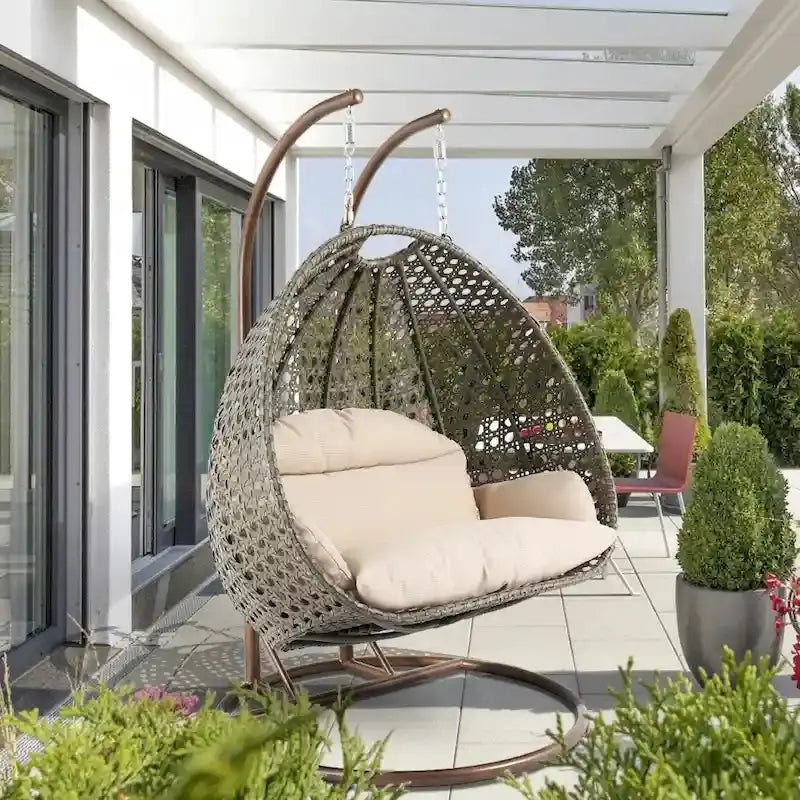 LeisureMod 2-Person Hanging Egg Chair – Indoor/Outdoor Rattan Wicker Swing with Stand and Cushioned Lounger